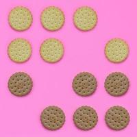 Pattern of a brown biscuits on a pink background. Trendy minimal concept of food and dessert. Abstract flat lay, top view photo