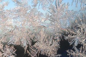 Snowflakes frost rime macro on window glass pane photo