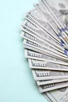 Fan of a US dollar bills of a new design lies on a light blue background photo