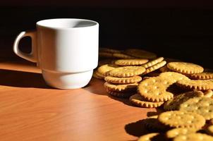 taza de café pequeña y galleta salada foto