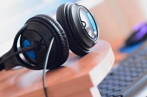 Big black headphones lie on the wooden desktop of the sound designer photo