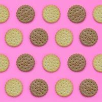 Pattern of a brown biscuits on a pink background. Trendy minimal concept of food and dessert. Abstract flat lay, top view photo