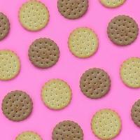 Pattern of a brown biscuits on a pink background. Trendy minimal concept of food and dessert. Abstract flat lay, top view photo