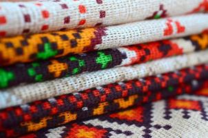 Stack of traditional Ukrainian folk art knitted embroidery patterns on textile fabric photo