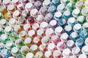 A pattern from a many nozzles from a paint sprayer for drawing graffiti, smeared into different colors. The plastic caps are arranged in many rows forming the color of the rainbow photo