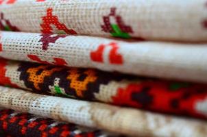 Stack of traditional Ukrainian folk art knitted embroidery patterns on textile fabric photo