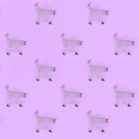 Shopping addiction, shopping lover or shopaholic concept. Many small empty shopping carts perform a pattern on a pastel colored paper background. Flat lay composition, top view photo