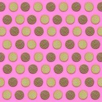 Pattern of a brown biscuits on a pink background. Trendy minimal concept of food and dessert. Abstract flat lay, top view photo