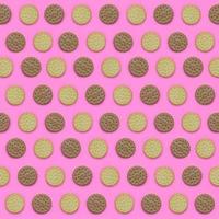 Pattern of a brown biscuits on a pink background. Trendy minimal concept of food and dessert. Abstract flat lay, top view photo