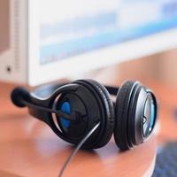 Big black headphones lie on the wooden desktop of the sound designer photo