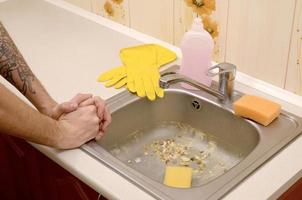 The housekeeper was faced with the problem of washing an overly dirty sink filled with food particles photo