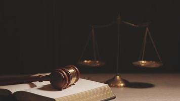 Justice and law concept.Male judge in a courtroom with the gavel, working with, computer and docking keyboard, eyeglasses, on table in morning light video