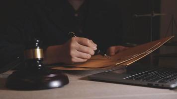 Justice and law concept.Male judge in a courtroom with the gavel, working with, computer and docking keyboard, eyeglasses, on table in morning light video