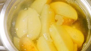 Boil the potatoes in an iron bowl. Macro shooting on intense steam video