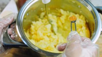 el chef hace galletas de patata con una bolsa de comida. Receta canónica de galletas de patata con brie, parmesano y nata. fotografía macro video