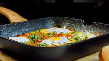 Fried eggs in Georgian cuisine, chirbuli. Eggs with tomatoes steaming in the pan video