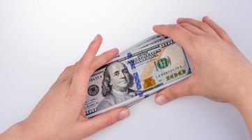mano humana sosteniendo billetes de dólar americano sobre fondo blanco