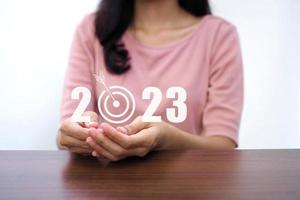 business woman holding number 2023 and copy space for merry christmas and happy new year concept. photo