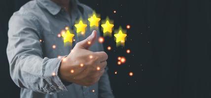 a businessman thumbs up on the five star to give satisfaction in service.rating very impressed.Customer service and Satisfaction concept. photo