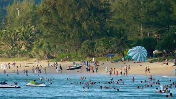 phuket, tailândia, 20 de novembro de 2018 - entretenimento de praia e multidão de pessoas em um movimentado dia de fim de semana na praia. conceito de turismo e viagens video