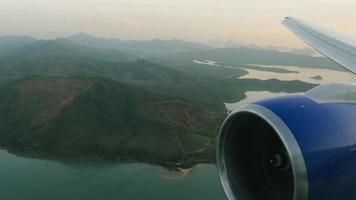 Visualizza a partire dal il aereo finestra per il azzurro mare di Tailandia. turisti arrivo per riposo su il isola di Phuket. turismo e viaggio concetto. video