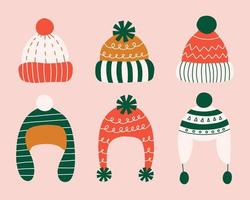 Set of different hand drawn winter hats with pompoms in flat style. vector