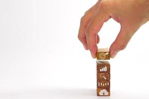Hand of businessman holding a wooden block with a target icon. Concept of Business success goals and strategy planning to success. photo