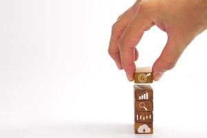 Hand of businessman holding a wooden block with a target icon. Concept of Business success goals and strategy planning to success. photo