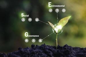 ESG icon concept in the hand for environmental, social, and governance in sustainable and ethical business on the Network connection on a green background. photo