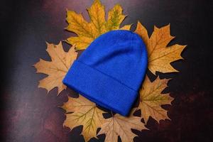 Blue knitted warm cap on dark brown concrete background photo