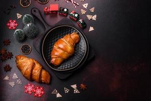 Beautiful different Christmas decorations and croissant on a brown concrete table photo