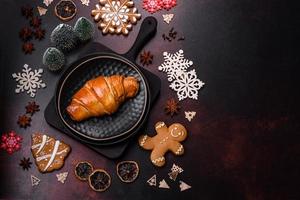 hermosos adornos navideños diferentes y croissant en una mesa de hormigón marrón