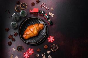 hermosos adornos navideños diferentes y croissant en una mesa de hormigón marrón foto