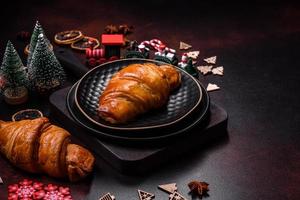 hermosos adornos navideños diferentes y croissant en una mesa de hormigón marrón