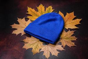 Blue knitted warm cap on dark brown concrete background photo