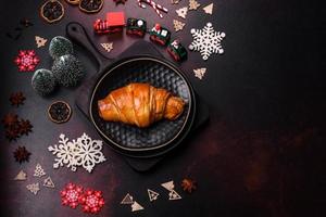 Beautiful different Christmas decorations and croissant on a brown concrete table photo