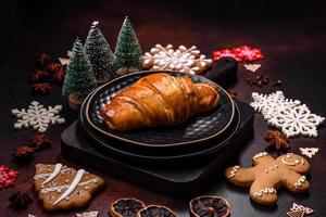 Beautiful different Christmas decorations and croissant on a brown concrete table photo
