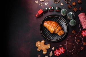 hermosos adornos navideños diferentes y croissant en una mesa de hormigón marrón foto