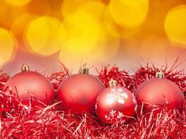 Xmas red balls on blurred orange background photo