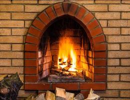 open fire in indoor brick fireplace photo