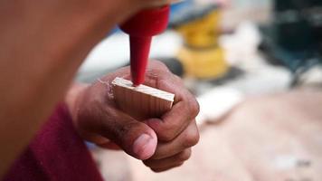 Putting wood glue onto a wooden board. Bonding wood in the workshop. Joiner, woodworker, carpenter applies glue to workpieces. Craftsmanship, handwork concept. video