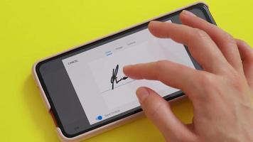 Electonic signature on phone screen, yellow background desk. video