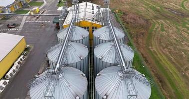 flight over agro silos granary elevator on agro-processing manufacturing plant for processing drying cleaning and storage of agricultural products, flour, cereals and grain. video
