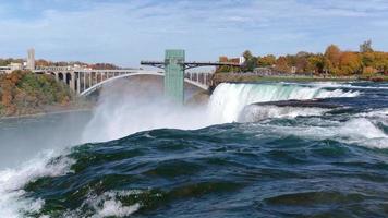 Niagarafälle von der amerikanischen und kanadischen Seite. Regenbogen über dem Wasserfall. der beliebteste Touristenort. stürmischer Fluss, der in den See mündet. video