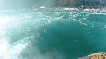 Niagarafälle von der amerikanischen und kanadischen Seite. Regenbogen über dem Wasserfall. der beliebteste Touristenort. stürmischer Fluss, der in den See mündet. video