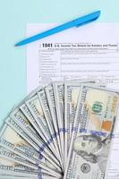 1041 tax form lies near hundred dollar bills and blue pen on a light blue background. US Income tax return for estates and trusts photo