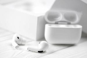 KHARKIV, UKRAINE - JANUARY 27, 2022 Apple AirPods Pro on a white background. Wireless headphones with charging case and a box. Apple Inc. is an American technology company photo