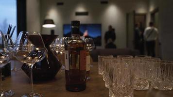 bicchieri di il whisky e vino con un' piazza caraffa su un' nero pietra sfondo nel un' lusso villa cinematico video. video