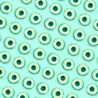 Many small plastic donuts lies on a pastel colorful background. Flat lay minimal pattern. Top view photo