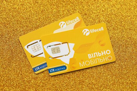 TERNOPIL, UKRAINE - JULY 5, 2022 Lifecell new sim card with free contract on yellow background. Lifecell is ukrainian mobile telephone network operator and provider of wireless connection photo